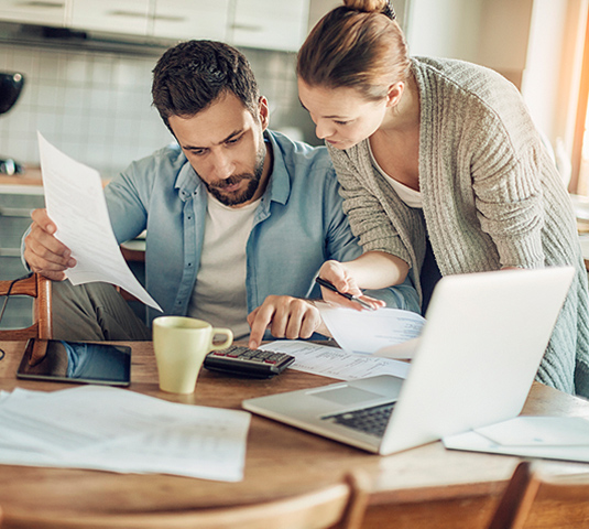 Couple reviewing paperwork and preparing their home to sell